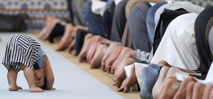 A child is seen near members of the Muslim community attending midday prayers at Strasbourg Grand Mosque in Strasbourg